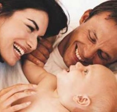 Молоді батьки з дитиною Щасливі батьки з немовлям